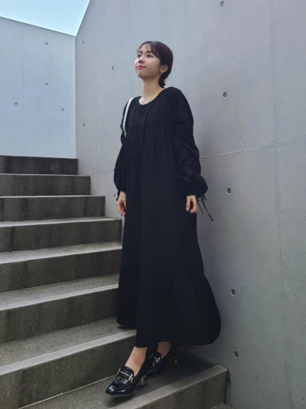 ブラック系のローファー、シルバー系のバッグ、ブラック系のワンピースを着用したレディースの春コーディネートの3枚目の写真