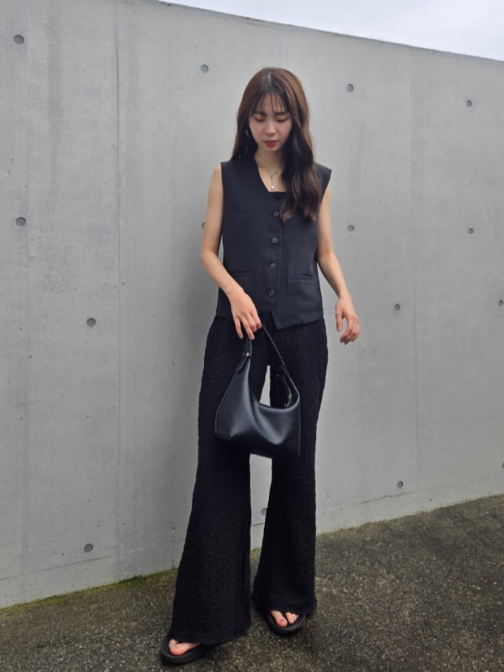 ブラック系のその他パンツ、ブラック系のハンドバッグ、ブラック系のサンダルを着用したレディースの夏コーディネートの2枚目の写真