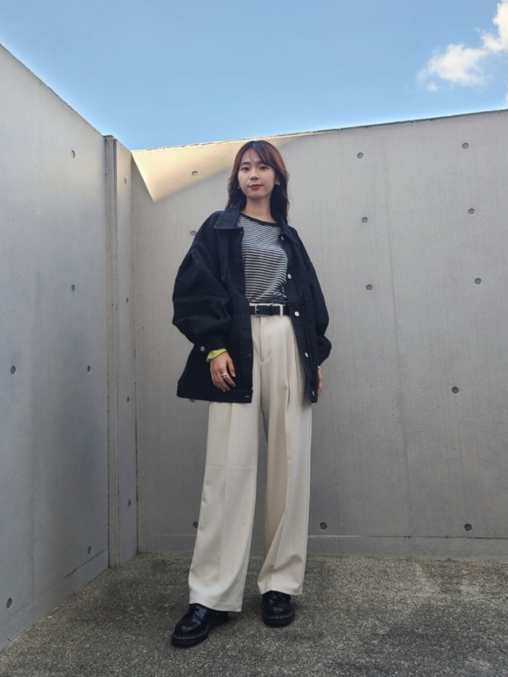 ブラック系のデニムジャケット、ブラック系のTシャツ/カットソー、ブラック系のブーツを着用したレディースの秋コーディネートの4枚目の写真