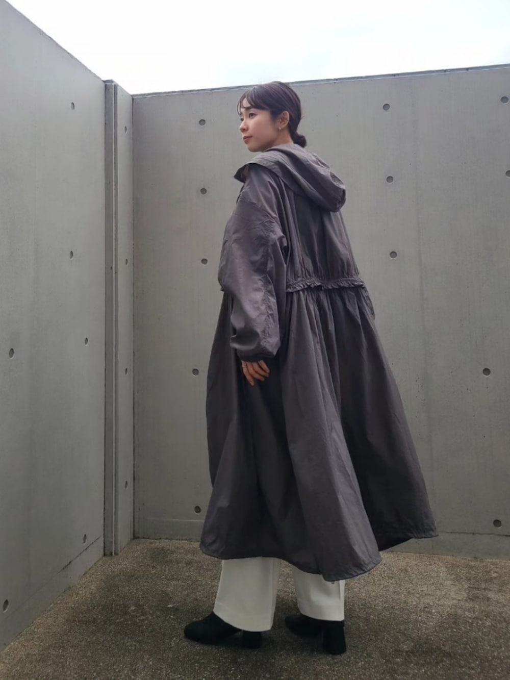 ブラック系のナイロンジャケット、ホワイト系のパンツ、ブラック系のブーツを着用したレディースの春コーディネートの3枚目の写真