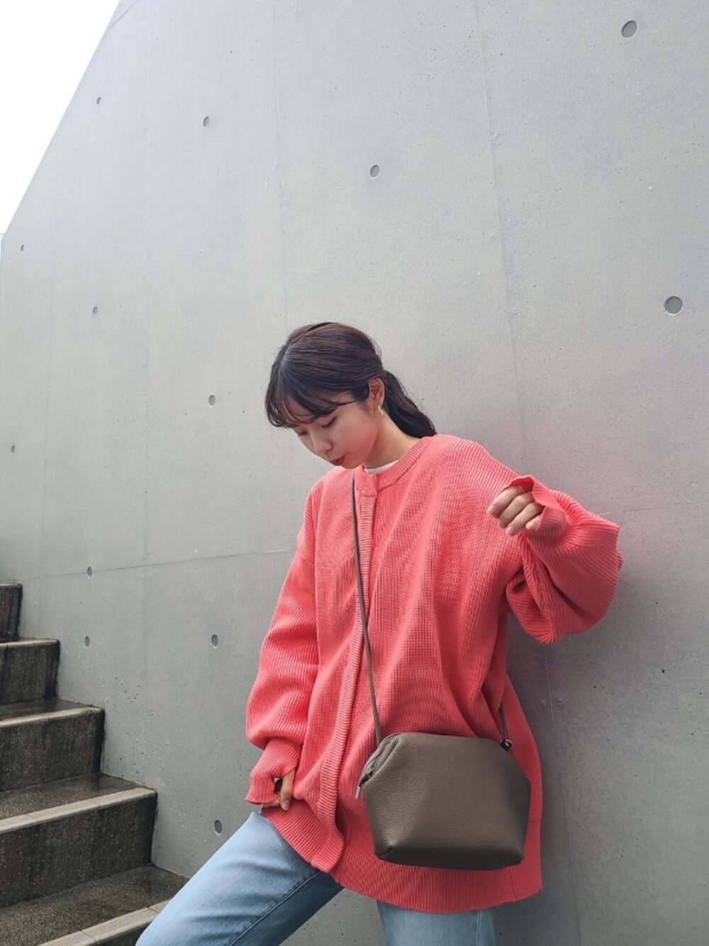 ブルー系のデニムパンツ、ホワイト系のスニーカー、ピンク系のカーディガン/ボレロを着用したレディースの冬コーディネートの4枚目の写真