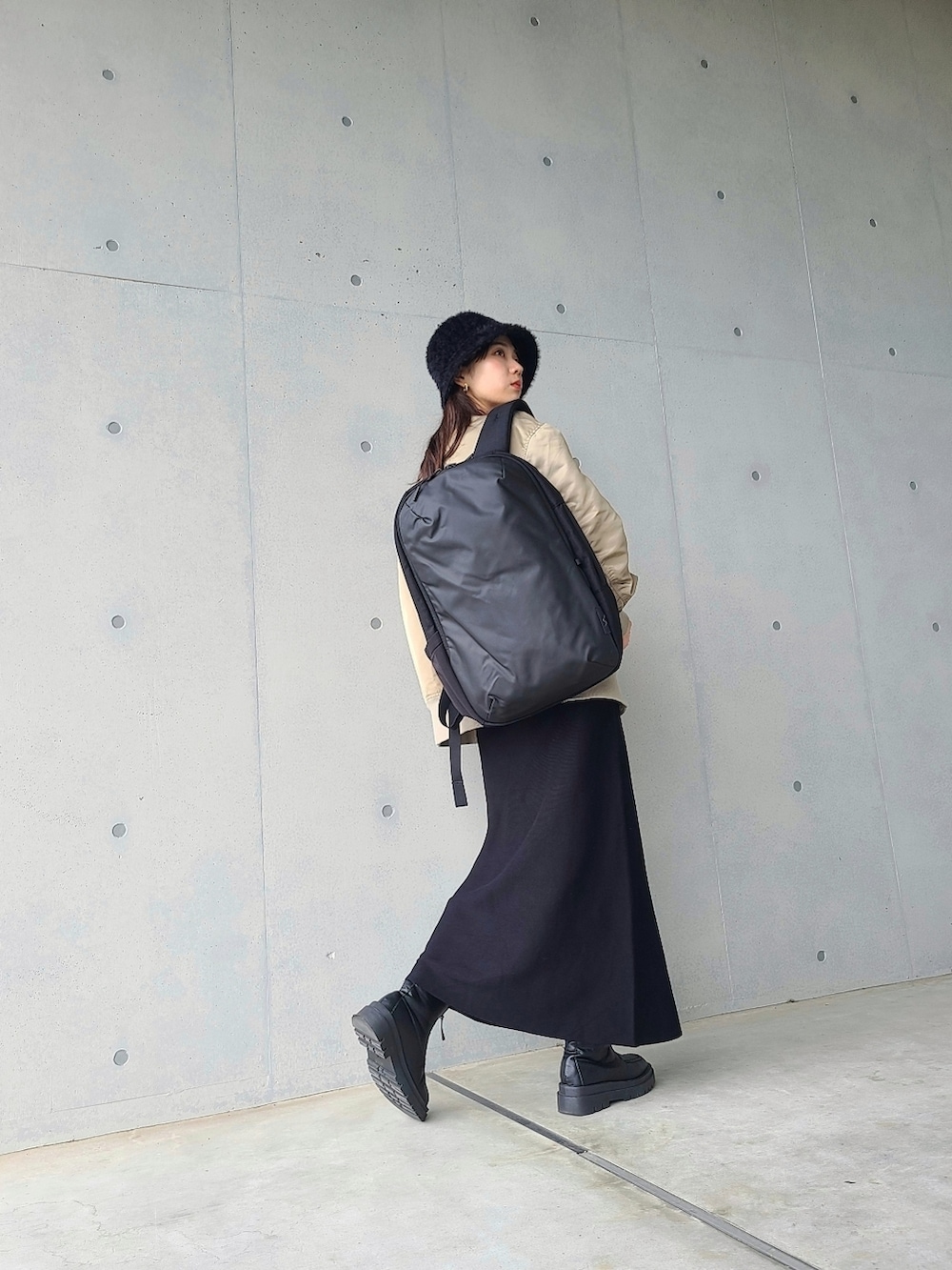 ベージュ系のMA-1、ブラック系のブーツ、ホワイト系のTシャツ/カットソーを着用したレディースの冬コーディネートの2枚目の写真