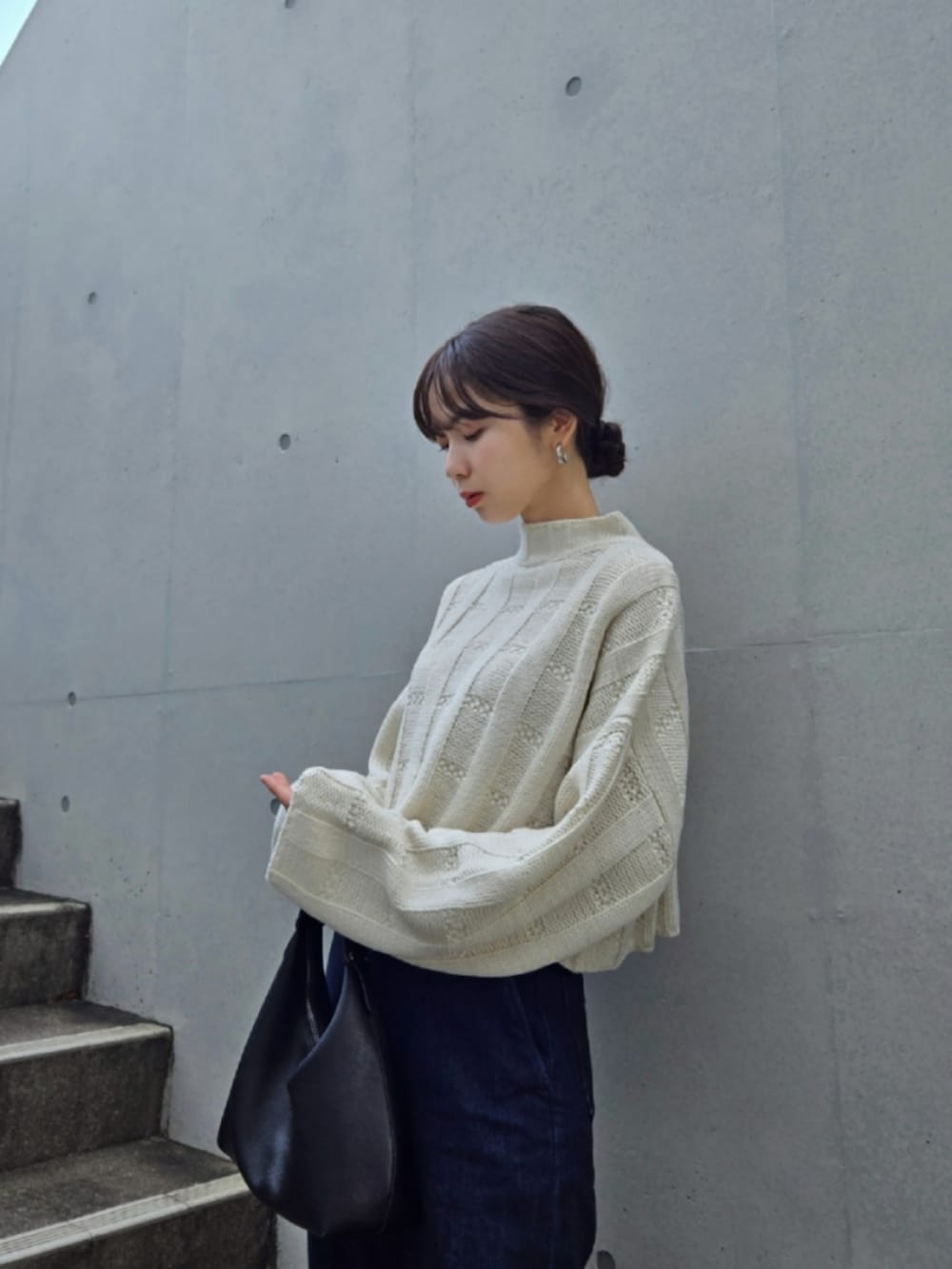 ホワイト系のニット/セーター、ブルー系のデニムパンツ、ブラック系のブーツを着用したレディースの秋コーディネートの4枚目の写真