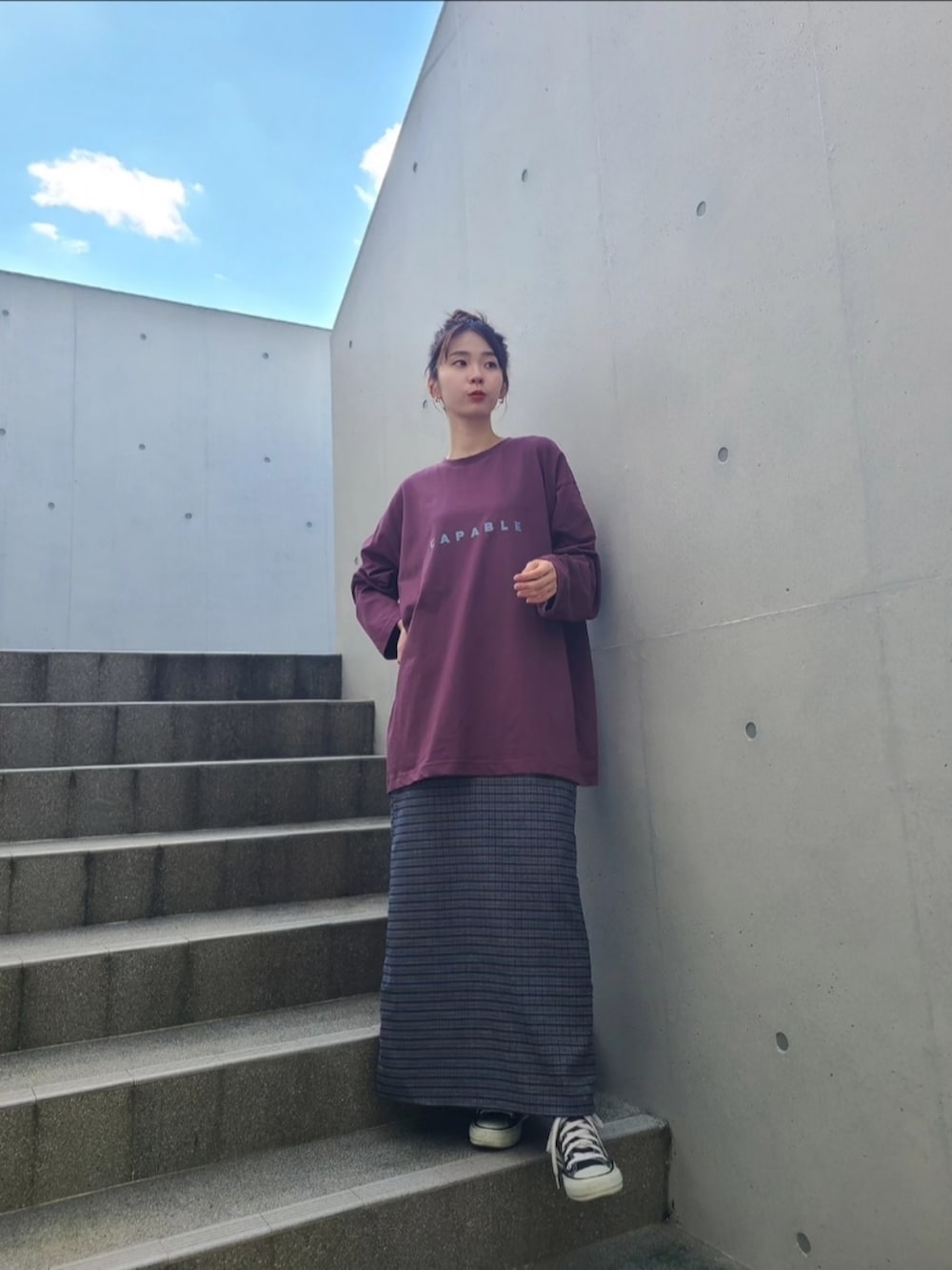 レッド系のTシャツ/カットソー、ブルー系のデニムジャケット、ブルー系のスカートを着用したレディースの秋コーディネートの4枚目の写真