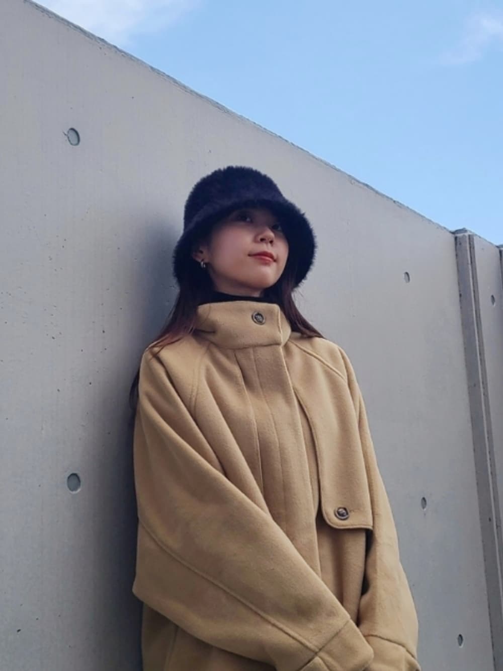 ブラック系のバッグ、ブラック系のブーツ、ベージュ系のその他アウターを着用したレディースの秋コーディネートの4枚目の写真