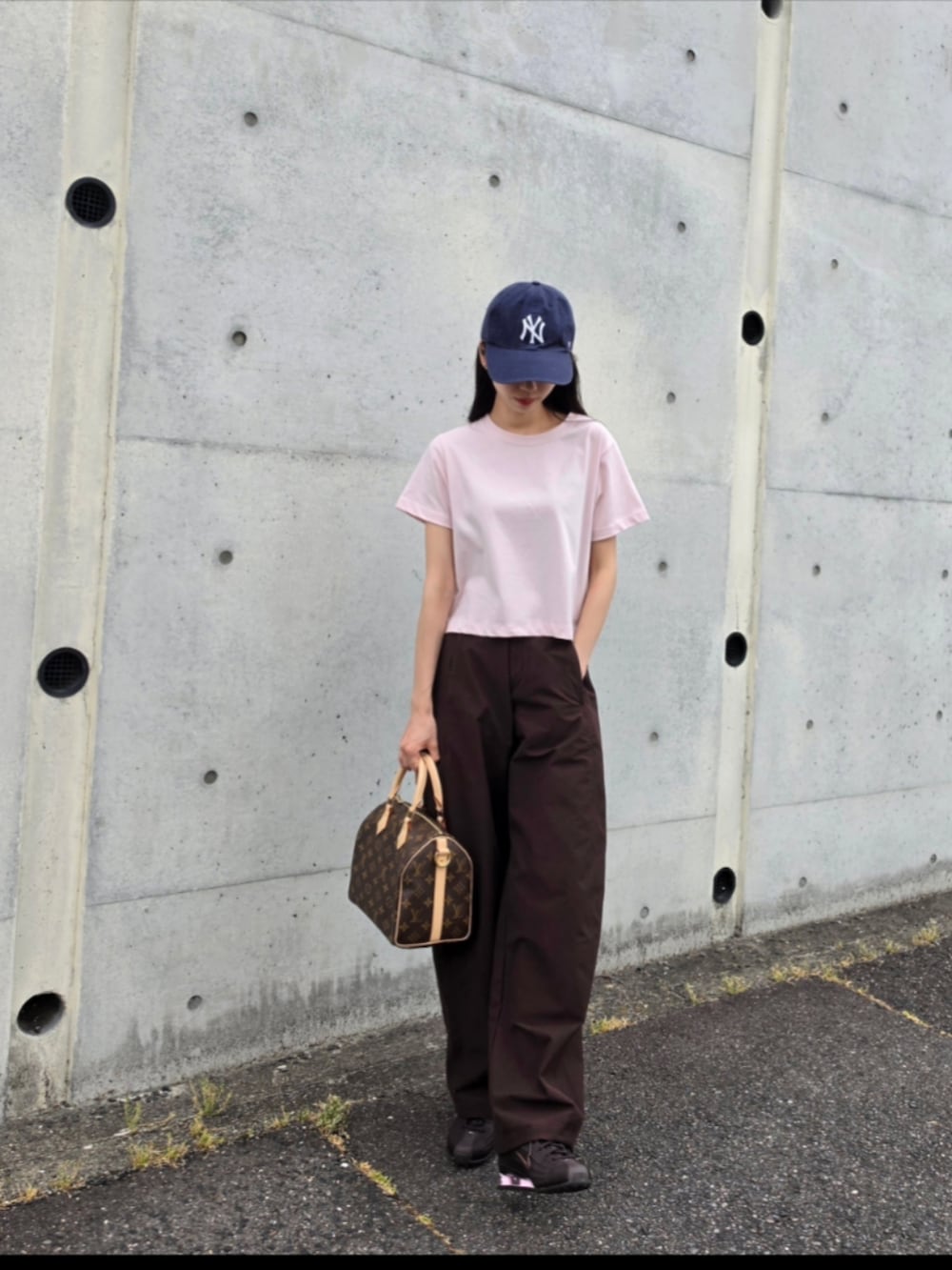 ピンク系のTシャツ/カットソー、ブラウン系のボストンバッグ、ブラウン系のパンツを着用したレディースの夏コーディネートの3枚目の写真