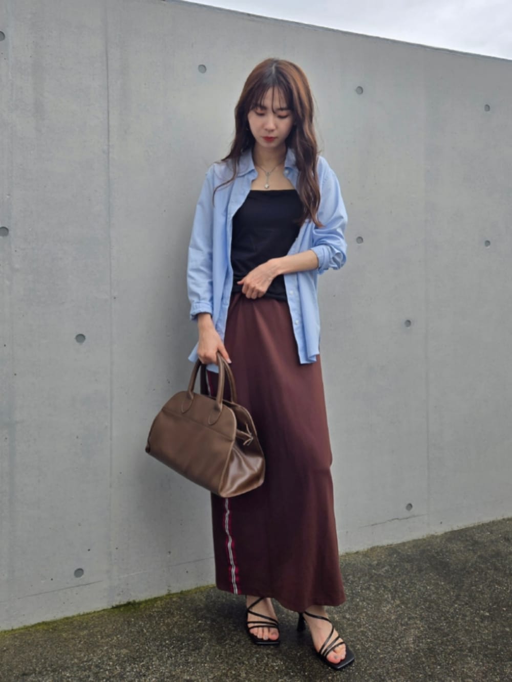 ブラウン系のスカート、ホワイト系のトップス、ブラウン系のボストンバッグを着用したレディースの夏コーディネートの2枚目の写真