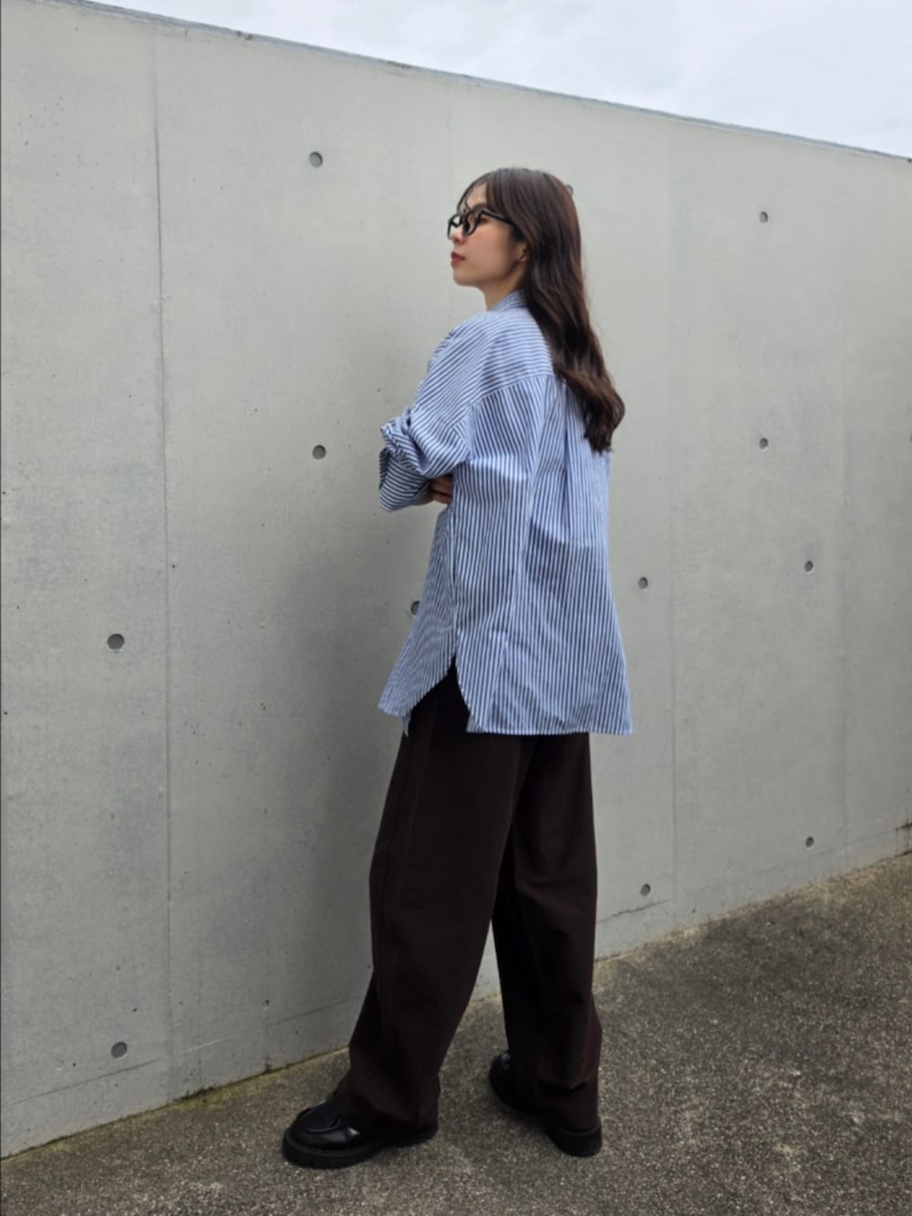 ブラウン系のパンツ、ブルー系のシャツ/ブラウス、ブラック系のシューズを着用したレディースの夏コーディネートの2枚目の写真