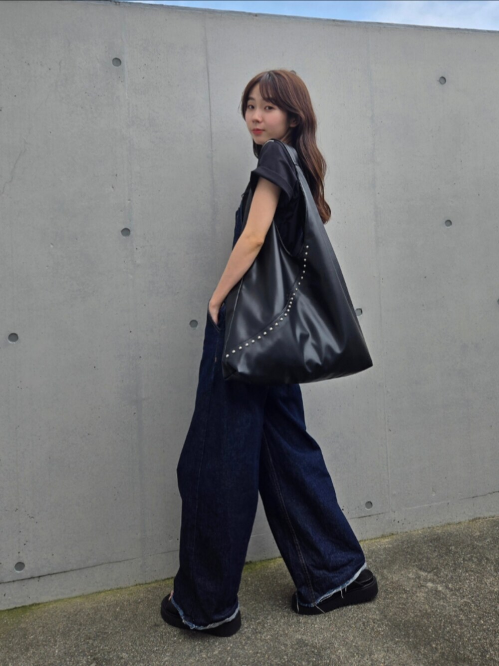 ブラック系のトートバッグ、ブルー系のサロペット/オーバーオール、ブラック系のサンダルを着用したレディースの夏コーディネートの2枚目の写真