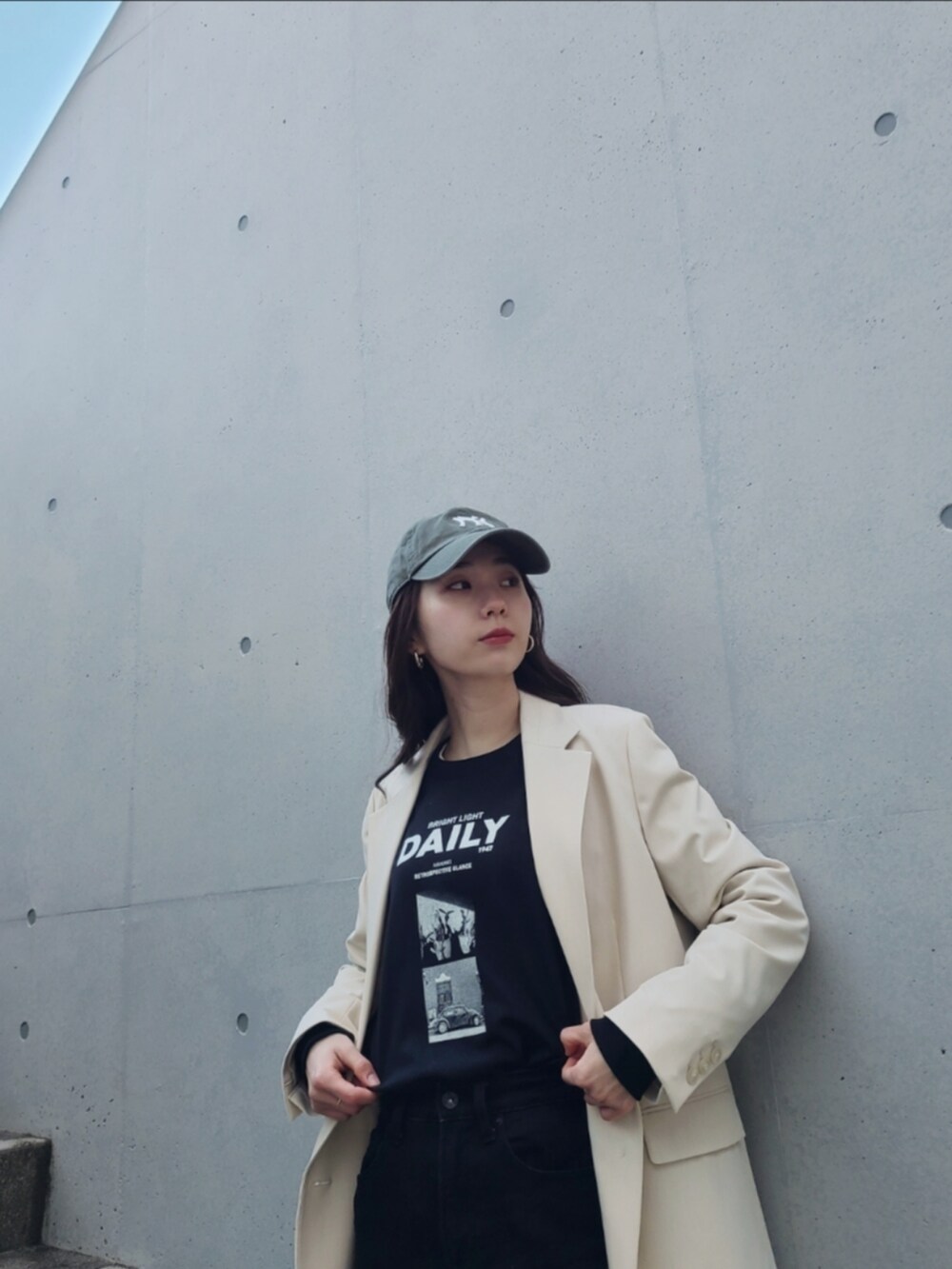 ブラック系のデニムパンツ、ホワイト系のテーラードジャケット、ブラック系のブーツを着用したレディースの冬コーディネートの2枚目の写真