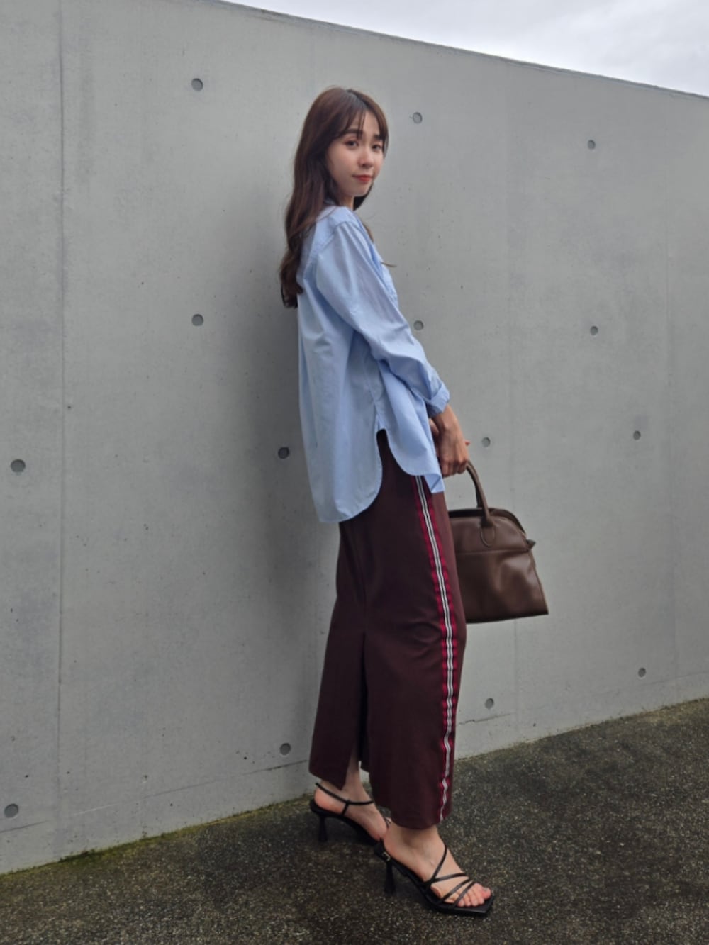 ブラウン系のスカート、ホワイト系のトップス、ブラウン系のボストンバッグを着用したレディースの夏コーディネートの3枚目の写真