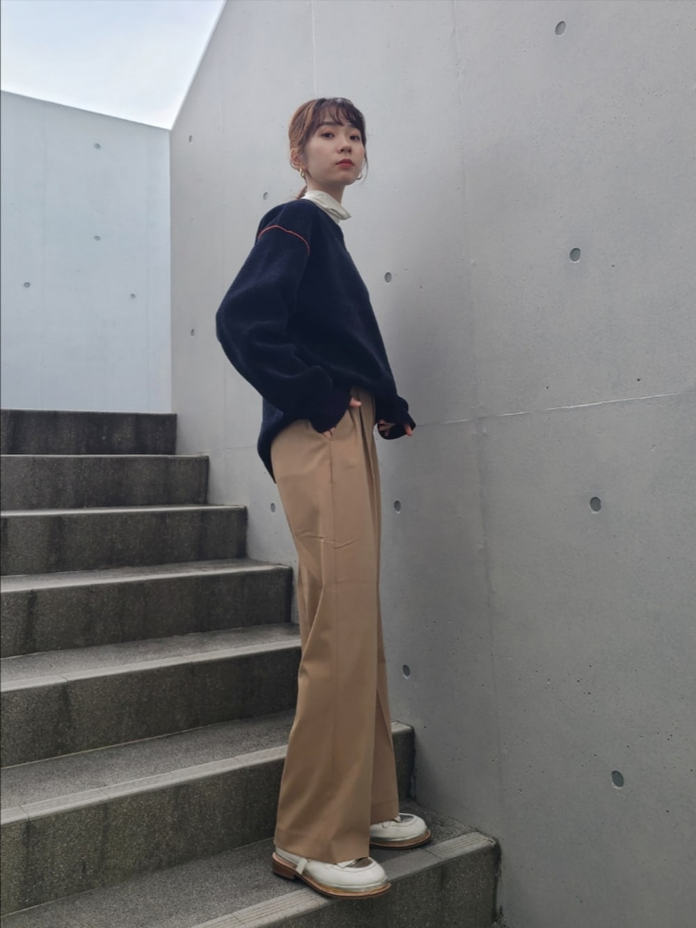 ブルー系のニット/セーター、ベージュ系のパンツ、ホワイト系のその他シューズを着用したレディースの冬コーディネートの3枚目の写真