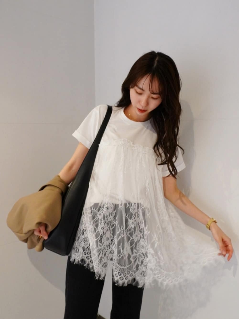 ホワイト系のTシャツ/カットソー、ブラック系のスニーカー、ブラック系のデニムパンツを着用したレディースの春コーディネートの2枚目の写真