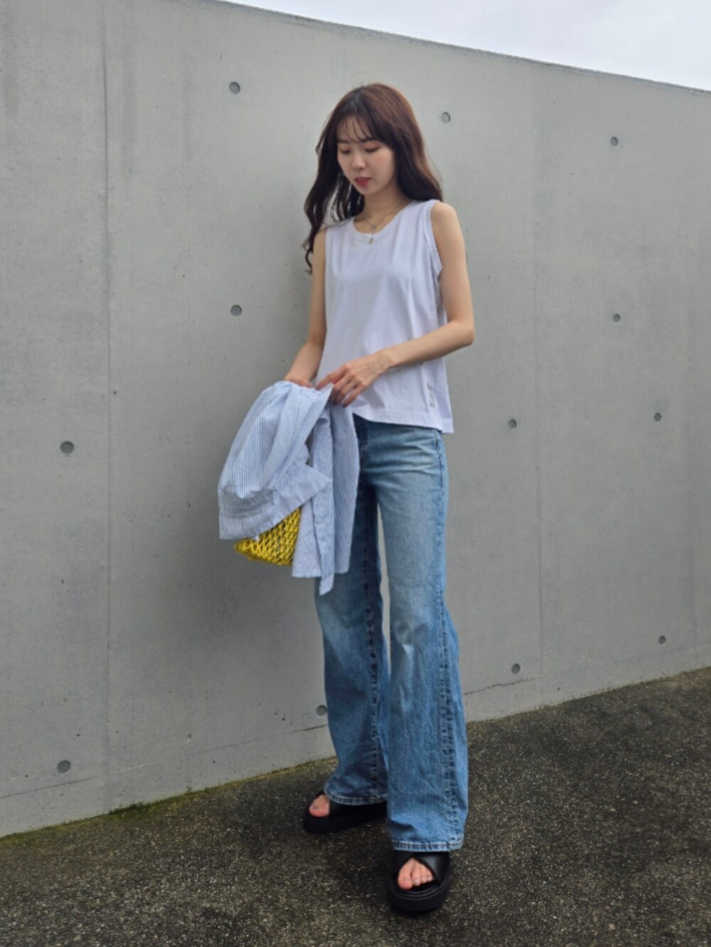 ブラック系のサンダル、ブルー系のデニムパンツ、ホワイト系のシャツ/ブラウスを着用したレディースの夏コーディネートの2枚目の写真