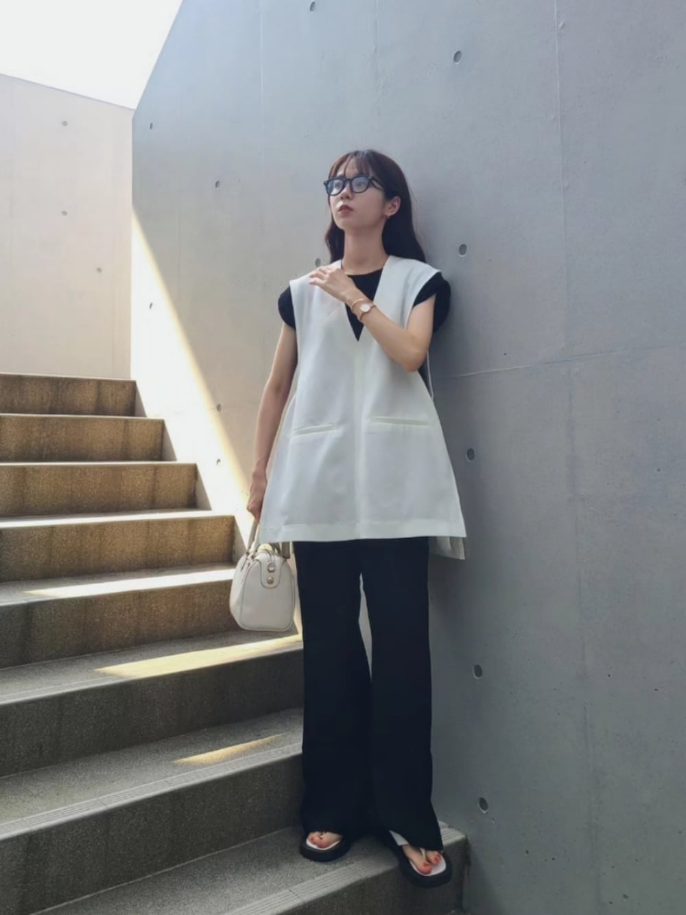 ブラック系のその他パンツ、ブラック系のTシャツ/カットソー、ホワイト系のサンダルを着用したレディースの夏コーディネートの2枚目の写真