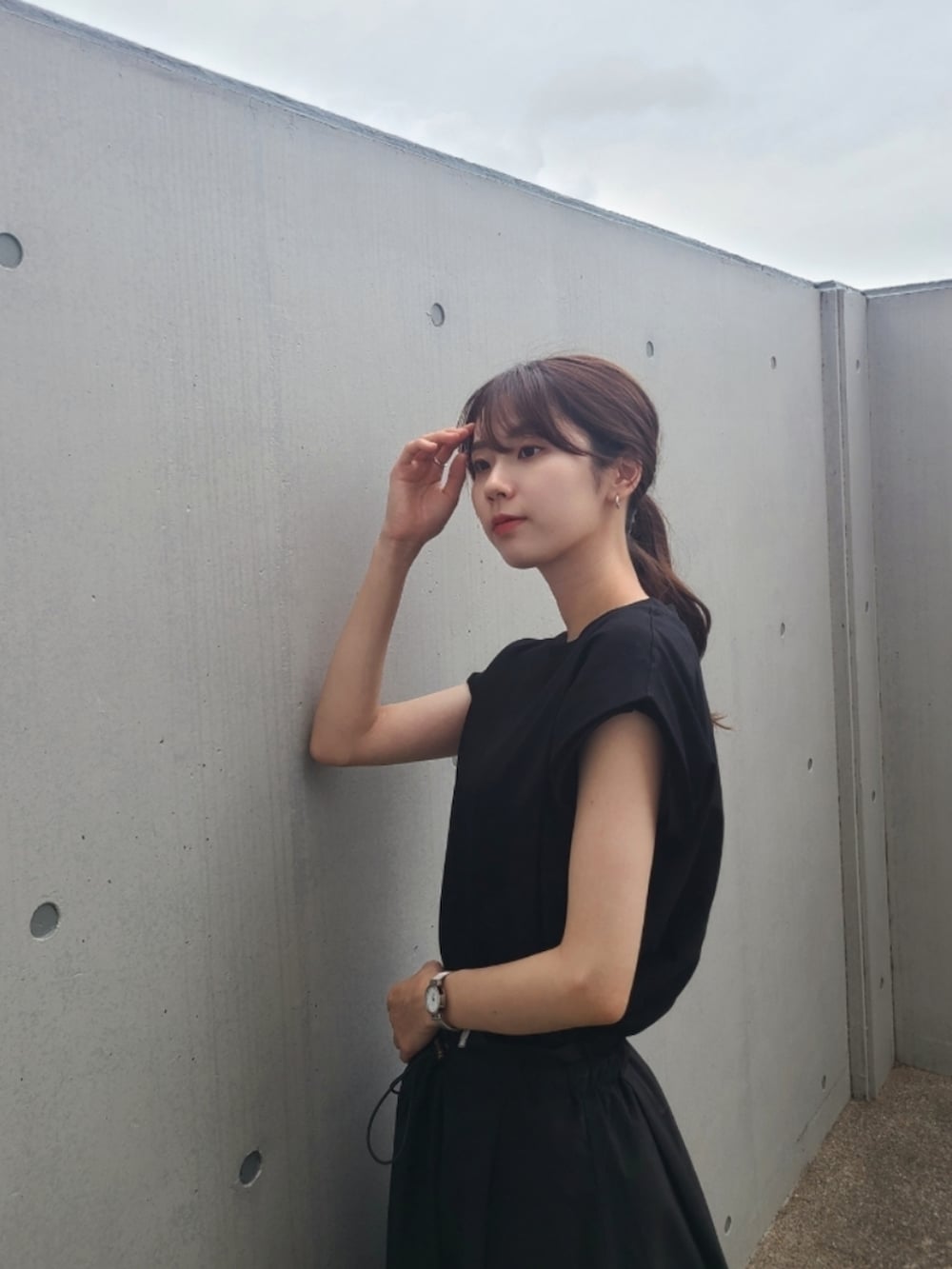 ブラック系のTシャツ/カットソー、ブラック系のスカート、ブラック系のスニーカーを着用したレディースの夏コーディネートの2枚目の写真