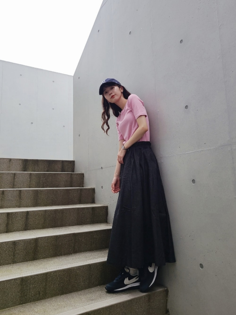 ブラック系のデニムスカート、ブルー系のスニーカー、ブルー系のスニーカーを着用したレディースの夏コーディネートの2枚目の写真