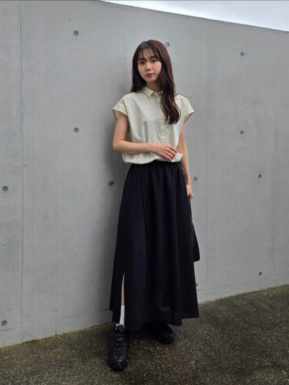 ブラック系のスニーカー、ブラック系のスカート、ホワイト系のシャツ/ブラウスを着用したレディースの春コーディネートの4枚目の写真