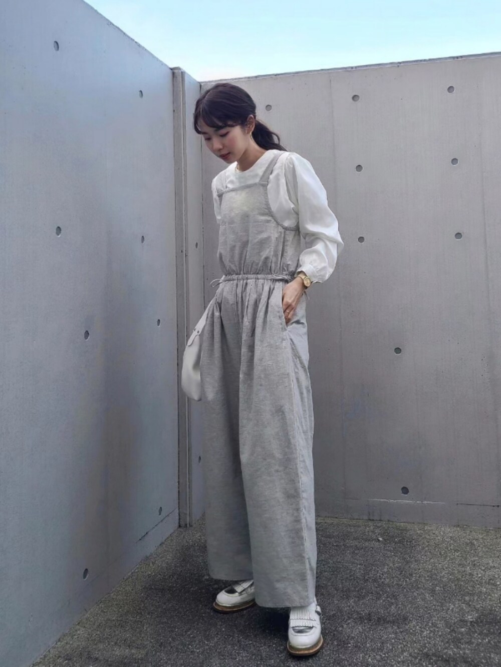 ホワイト系のその他シューズ、グレー系のサロペット/オーバーオール、ゴールド系のアナログ腕時計を着用したレディースの冬コーディネートの3枚目の写真