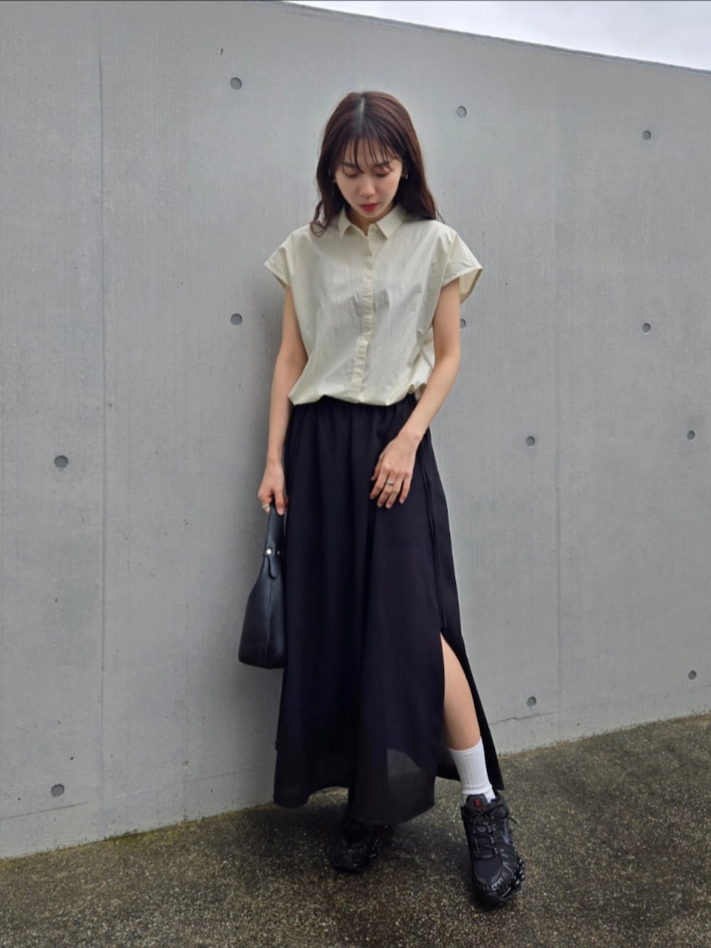 ブラック系のスニーカー、ブラック系のスカート、ホワイト系のシャツ/ブラウスを着用したレディースの春コーディネートの5枚目の写真