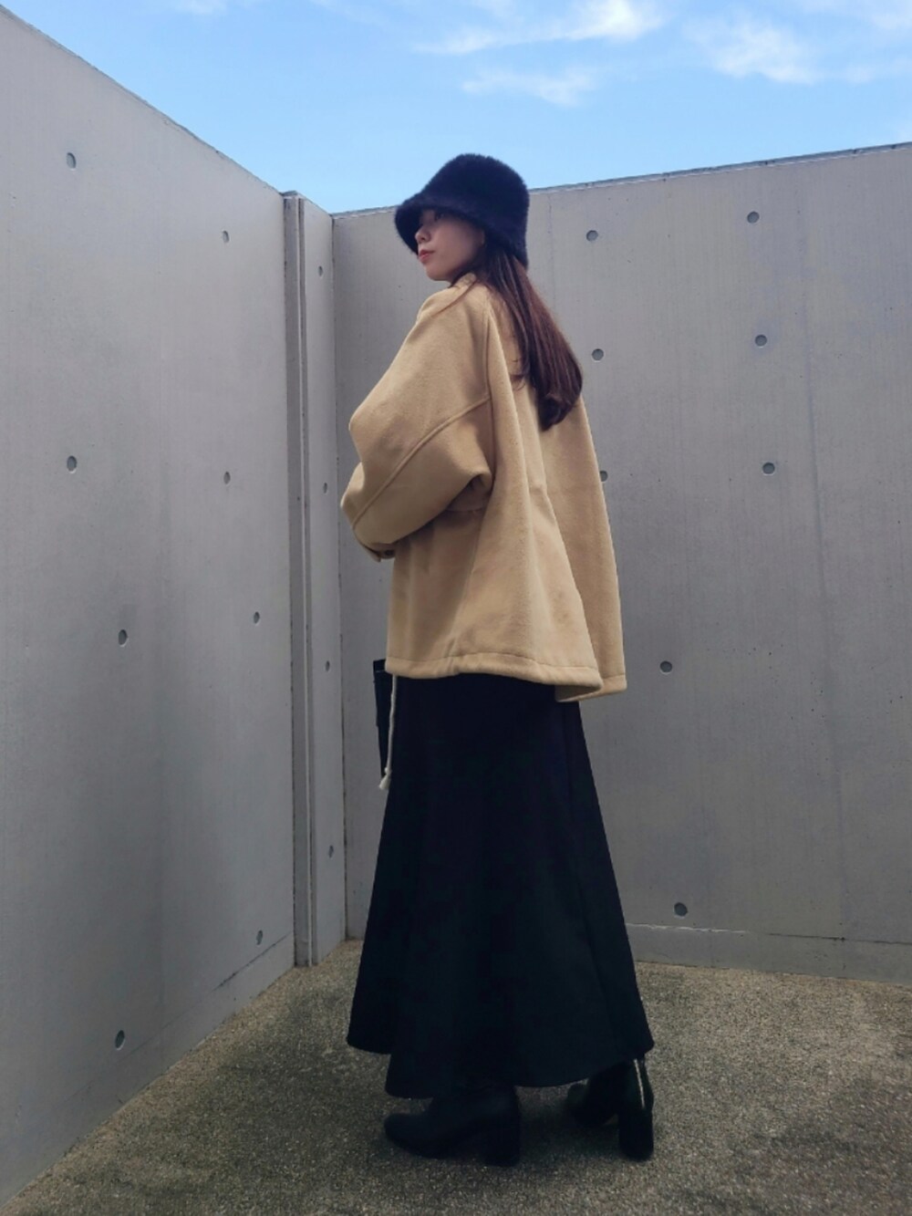 ブラック系のバッグ、ブラック系のブーツ、ベージュ系のその他アウターを着用したレディースの秋コーディネートの2枚目の写真