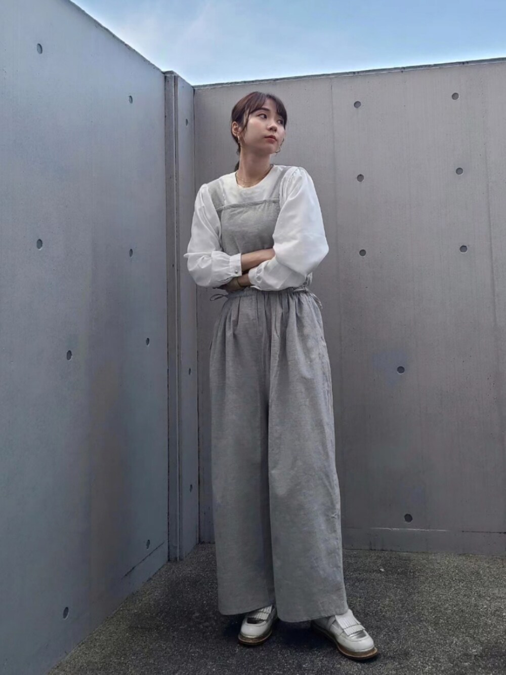 ホワイト系のその他シューズ、グレー系のサロペット/オーバーオール、ゴールド系のアナログ腕時計を着用したレディースの冬コーディネートの2枚目の写真