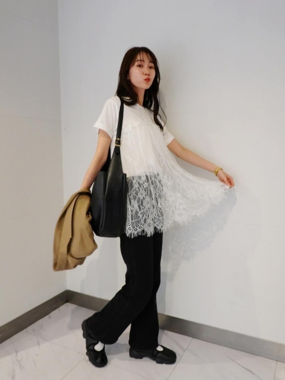 ホワイト系のTシャツ/カットソー、ブラック系のスニーカー、ブラック系のデニムパンツを着用したレディースの春コーディネートの3枚目の写真