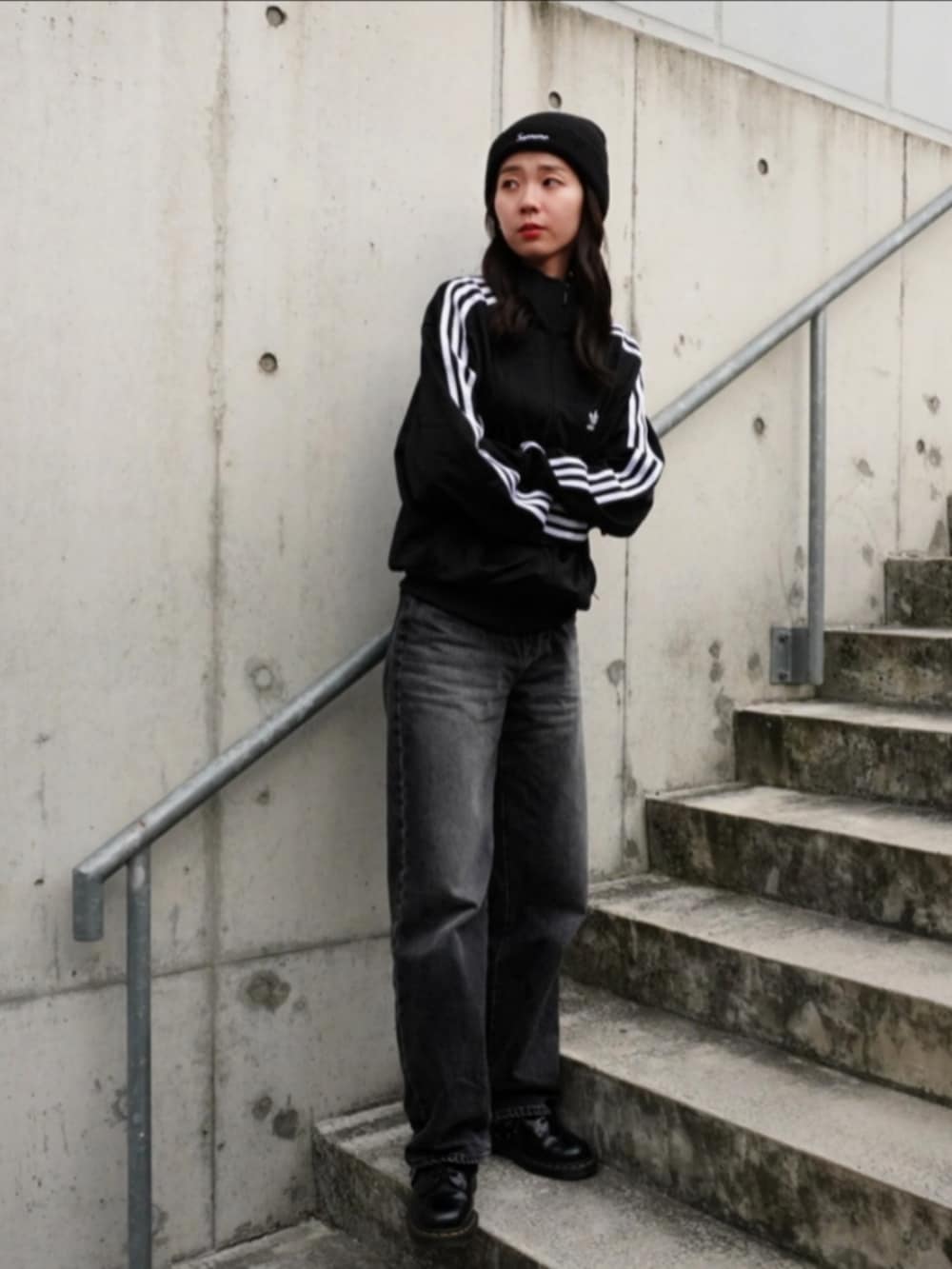 グレー系のデニムパンツ、ブラック系のハンドバッグ、ブラック系のジャージを着用したレディースの秋コーディネートの3枚目の写真