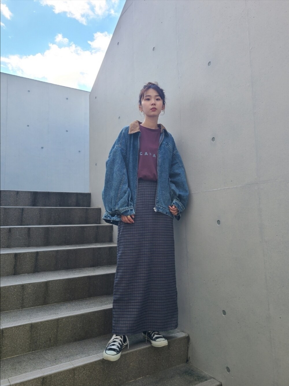 レッド系のTシャツ/カットソー、ブルー系のデニムジャケット、ブルー系のスカートを着用したレディースの秋コーディネートの5枚目の写真