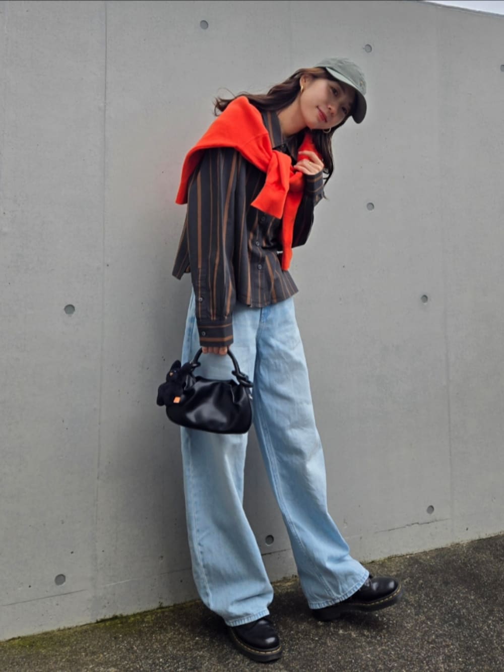 ブルー系のデニムパンツ、グレー系のシャツ/ブラウス、ブラック系のブーツを着用したレディースの秋コーディネートの2枚目の写真