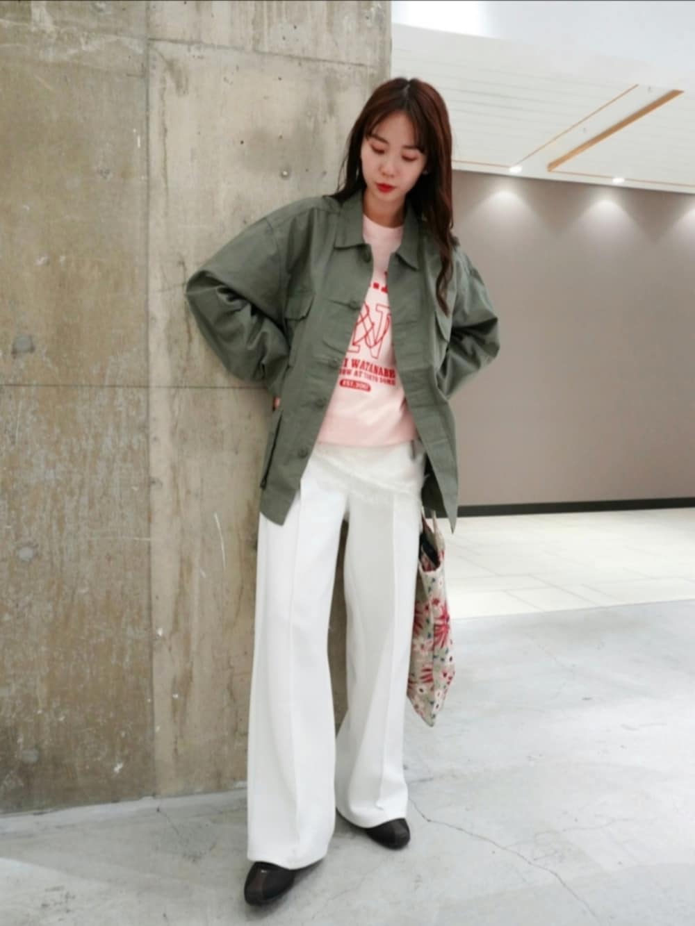 グリーン系のミリタリージャケット、ベージュ系のショルダーバッグ、ホワイト系のその他パンツを着用したレディースの春コーディネートの4枚目の写真
