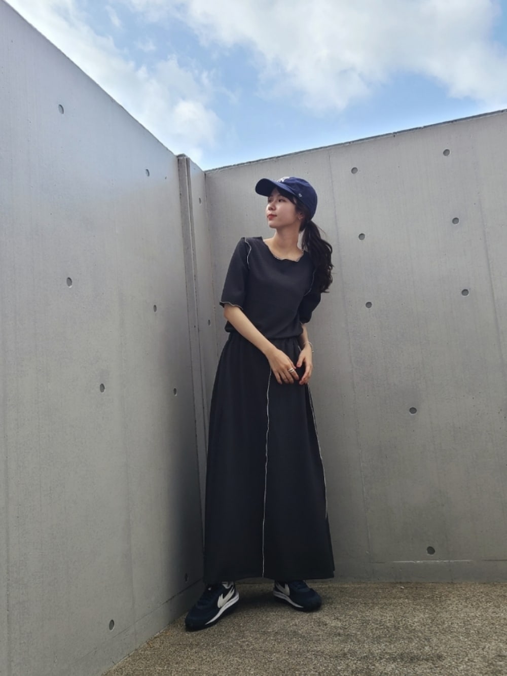 グレー系のTシャツ/カットソー、グレー系のスカート、ブルー系のスニーカーを着用したレディースの春コーディネートの3枚目の写真