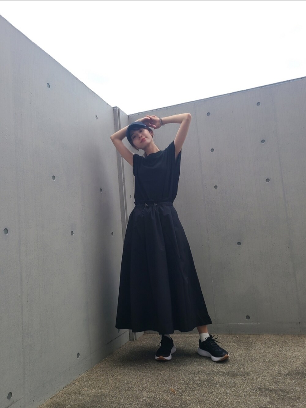 ブラック系のTシャツ/カットソー、ブラック系のスカート、ブラック系のスニーカーを着用したレディースの夏コーディネートの3枚目の写真