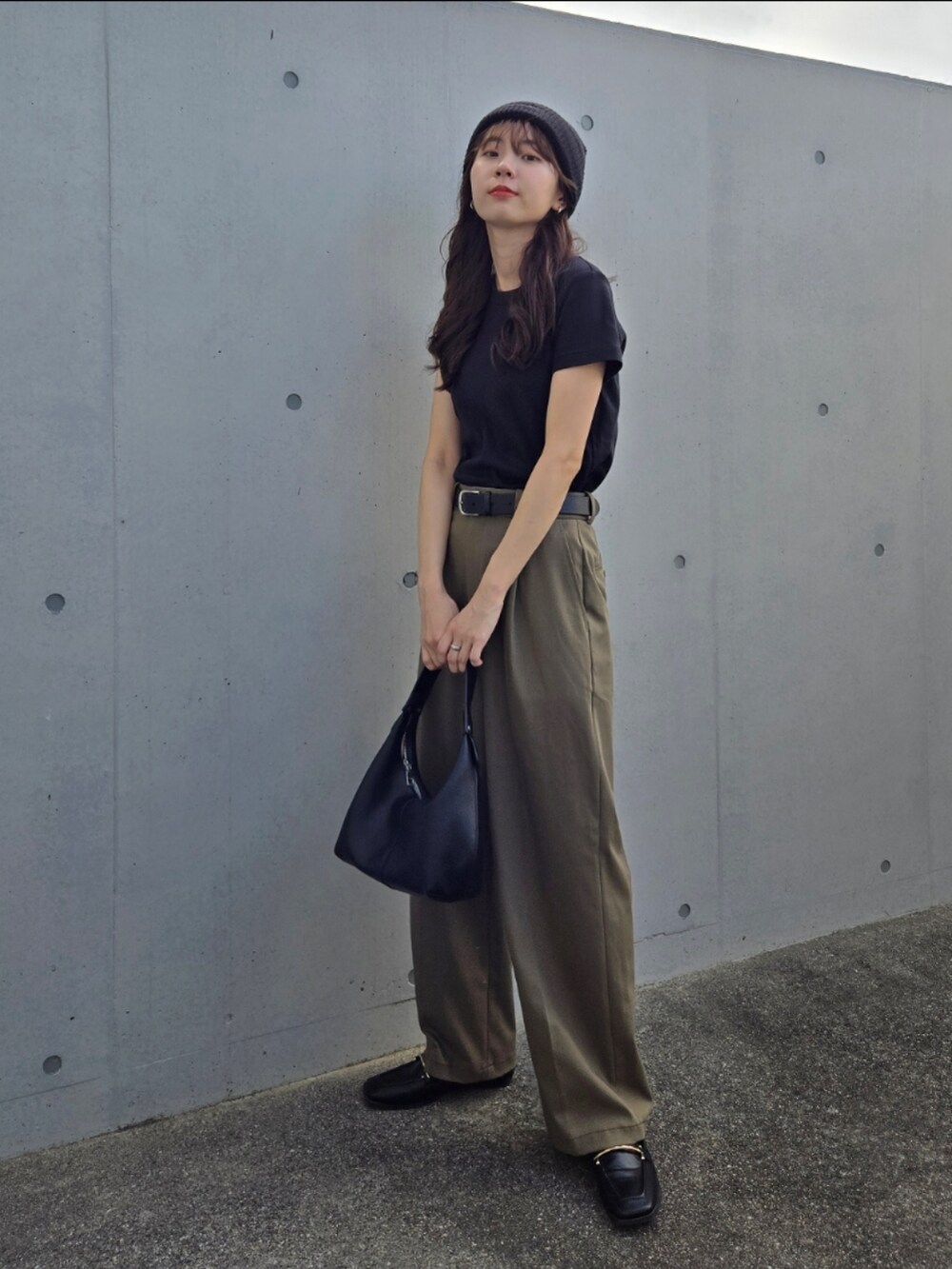 ブラック系のTシャツ/カットソー、ブラック系のハンドバッグ、グリーン系のパンツを着用したレディースの秋コーディネートの2枚目の写真