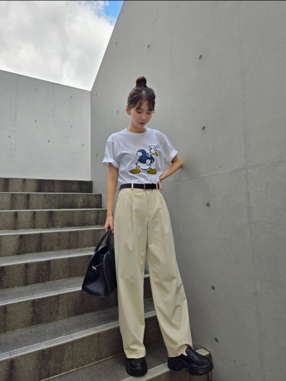 ブラック系のスニーカー、ホワイト系のTシャツ/カットソー、ホワイト系のパンツを着用したレディースの夏コーディネートの3枚目の写真