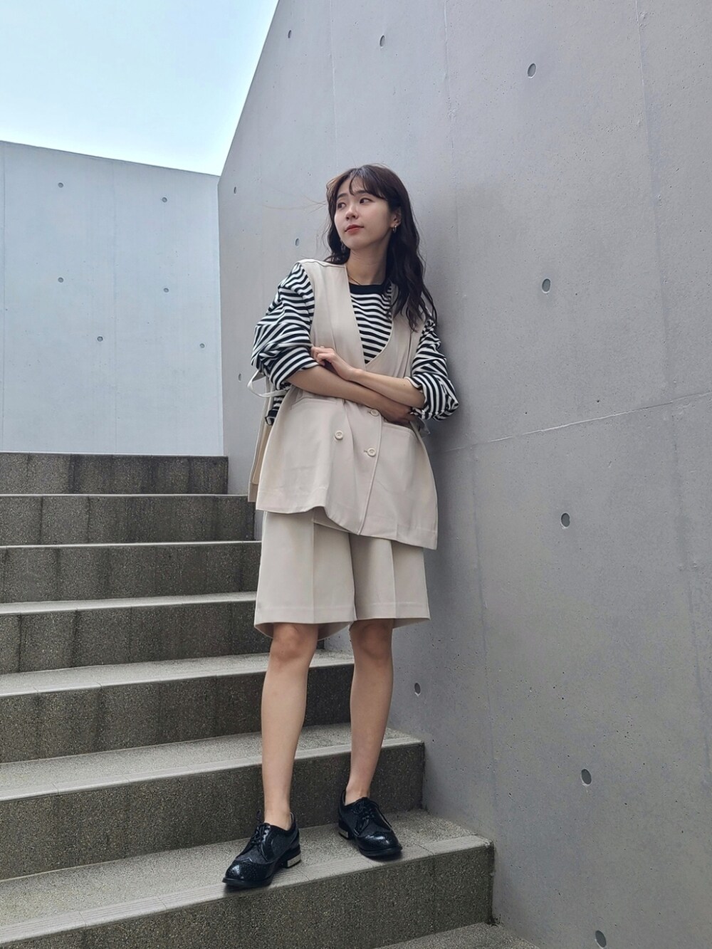 ホワイト系のベスト、ホワイト系のその他パンツ、ブラック系のローファーを着用したレディースの春コーディネートの2枚目の写真