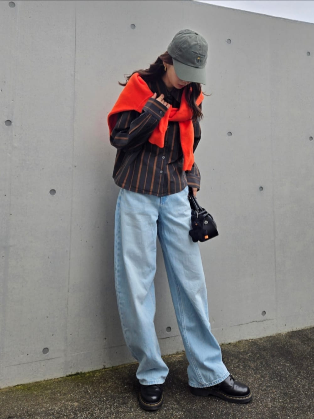 ブルー系のデニムパンツ、グレー系のシャツ/ブラウス、ブラック系のブーツを着用したレディースの秋コーディネートの5枚目の写真