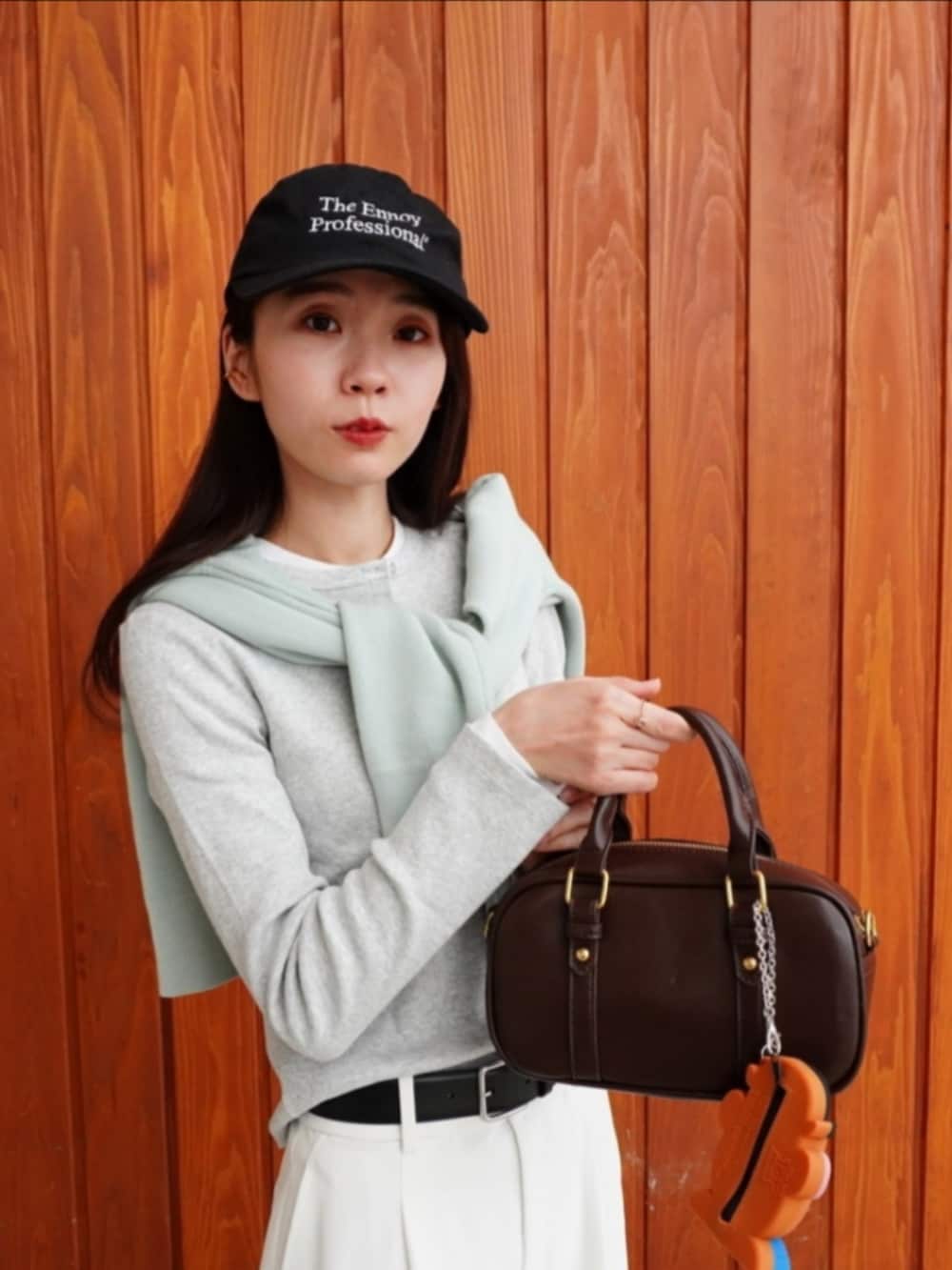 グレー系のパーカー、ホワイト系のパンツ、ホワイト系のスニーカーを着用したレディースの春コーディネートの4枚目の写真