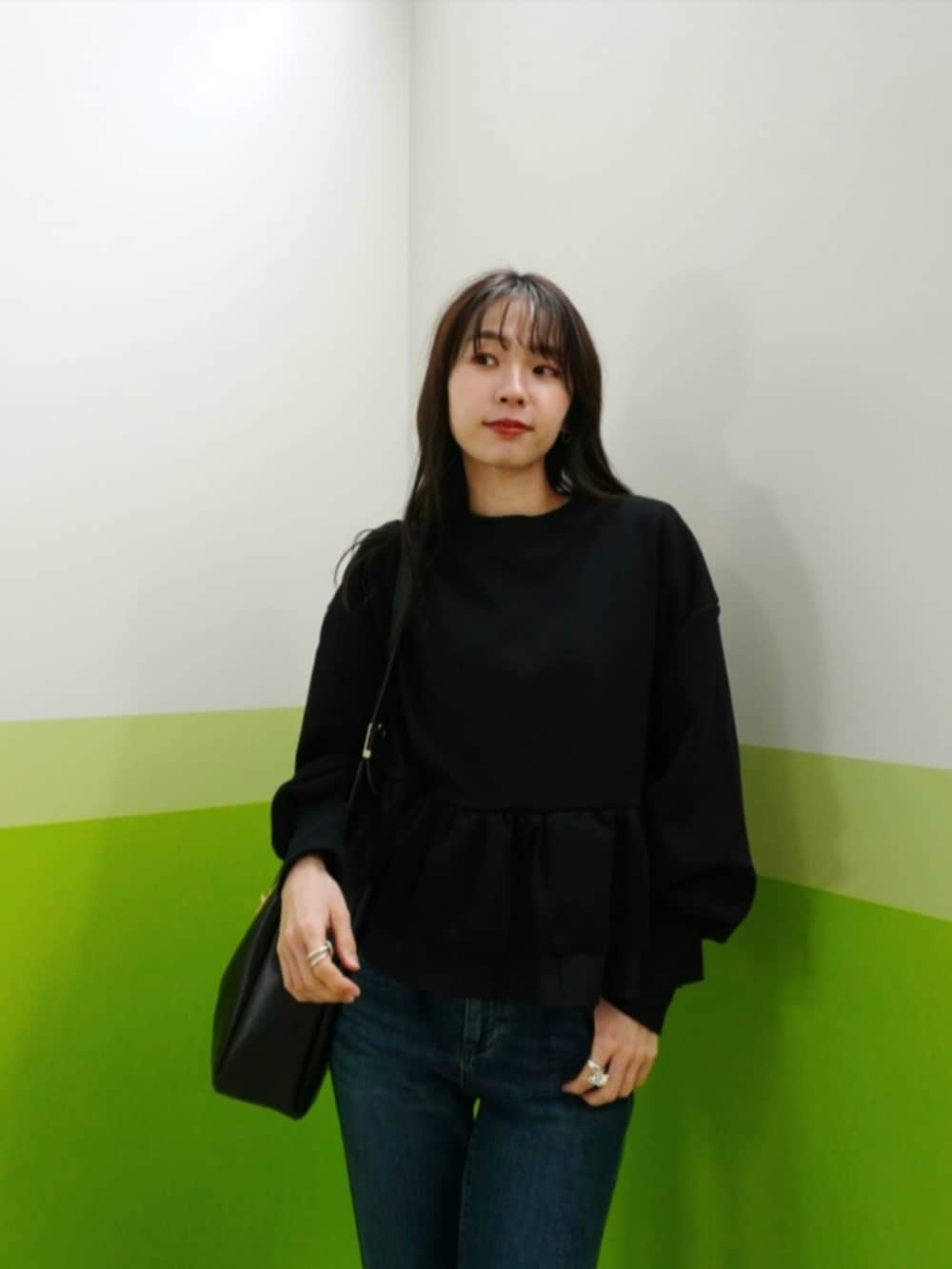 ブルー系のデニムパンツ、ブラック系のカーディガン/ボレロ、ブラック系のトートバッグを着用したレディースの冬コーディネートの4枚目の写真