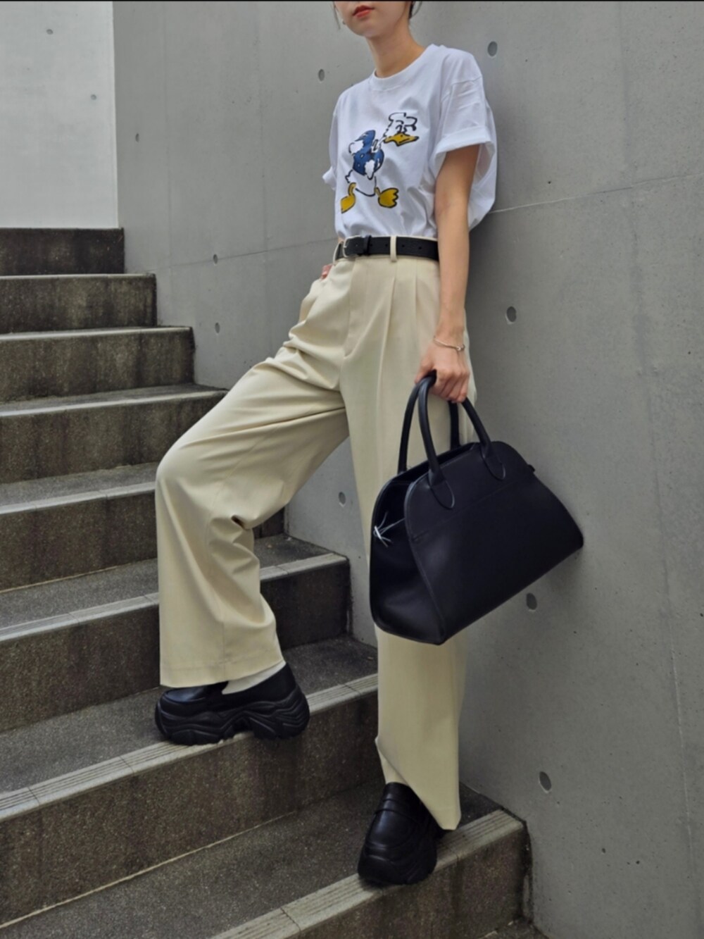 ブラック系のスニーカー、ホワイト系のTシャツ/カットソー、ホワイト系のパンツを着用したレディースの夏コーディネートの2枚目の写真