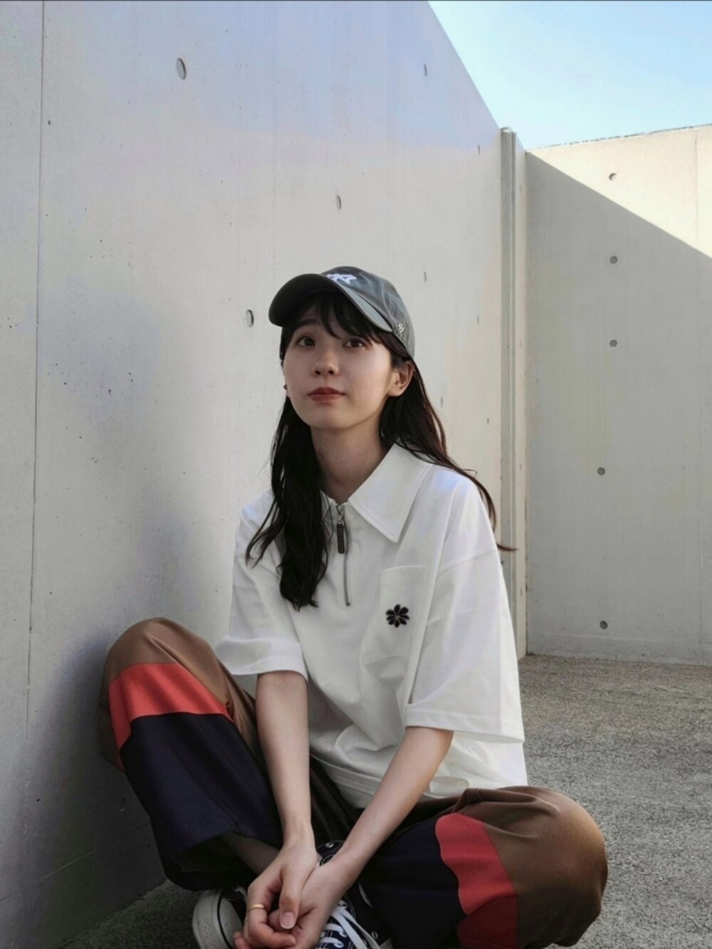 ブラウン系のその他パンツ、ホワイト系のTシャツ/カットソー、ブラック系のスニーカーを着用したレディースの春コーディネートの2枚目の写真