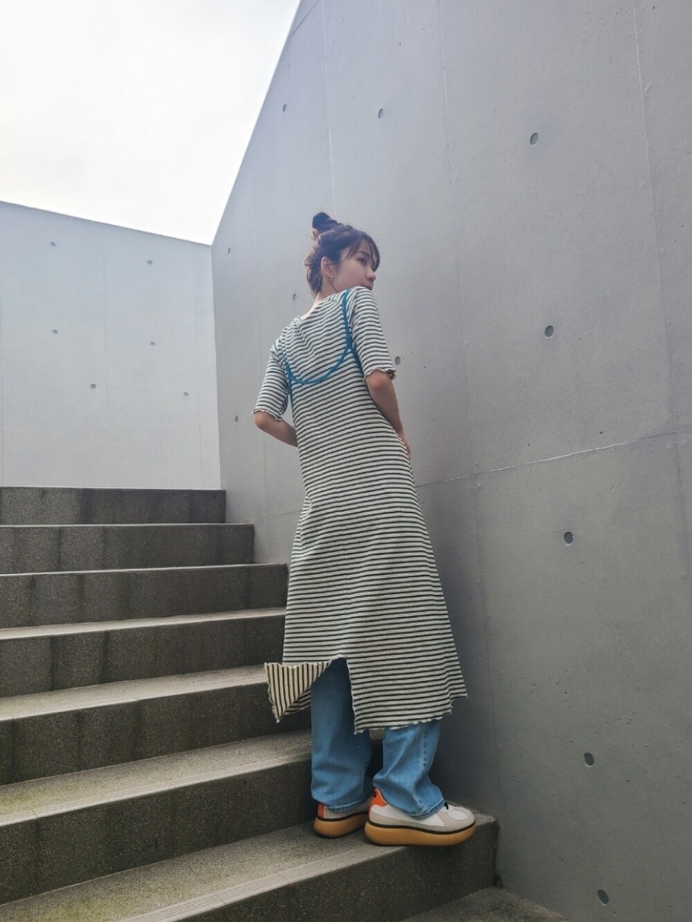 グリーン系のワンピース、グリーン系のTシャツ/カットソー、ホワイト系のスニーカーを着用したレディースの夏コーディネートの2枚目の写真