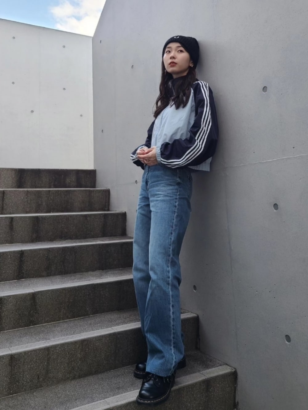 ブラック系のブーツ、ブルー系のナイロンジャケット、ブラック系のメッセンジャーバッグを着用したレディースの冬コーディネートの3枚目の写真