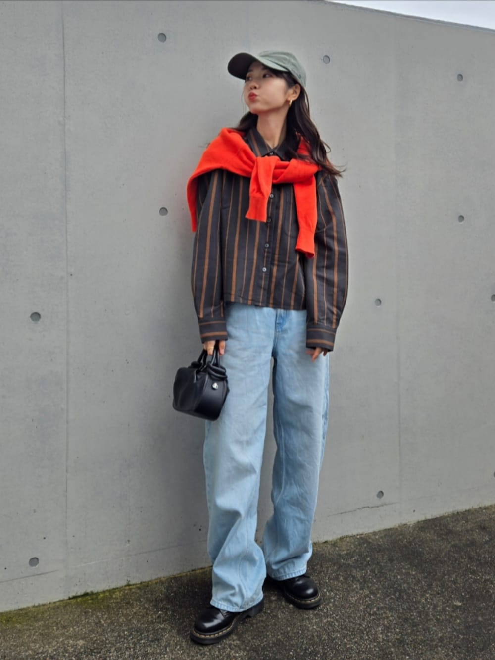 ブルー系のデニムパンツ、グレー系のシャツ/ブラウス、ブラック系のブーツを着用したレディースの秋コーディネートの4枚目の写真