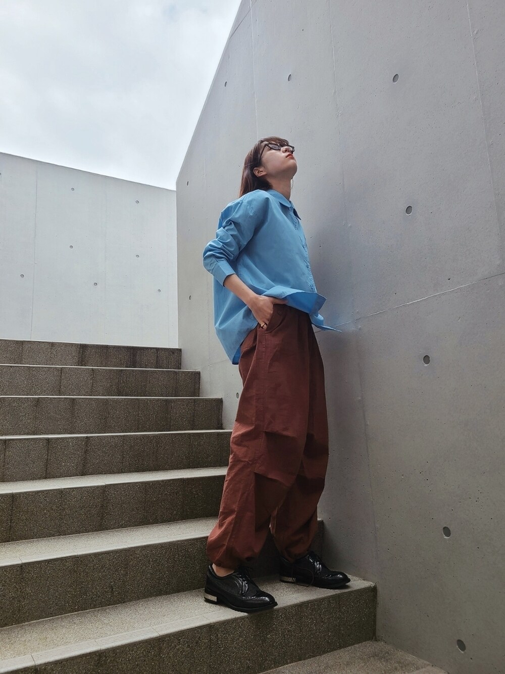 ブラウン系のカーゴパンツ、ブラック系のローファー、ブルー系のシャツ/ブラウスを着用したレディースの春コーディネートの2枚目の写真