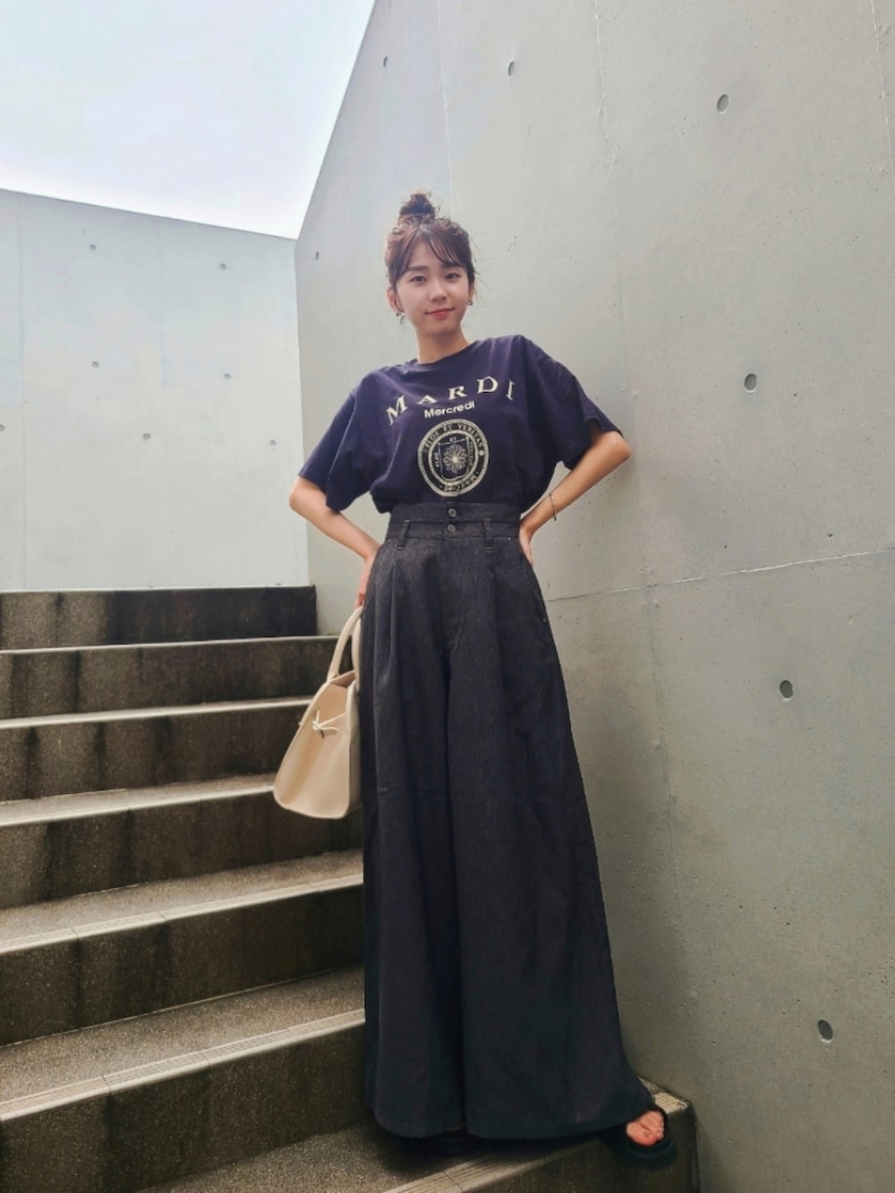 ブルー系のTシャツ/カットソー、ブラック系のサンダル、ブラック系のデニムパンツを着用したレディースの夏コーディネートの2枚目の写真
