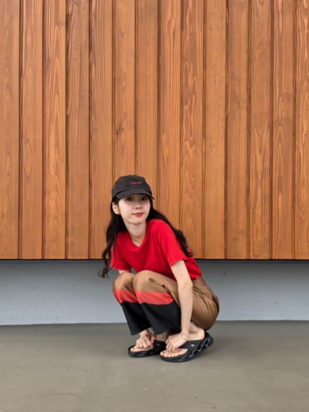 ブラウン系のその他パンツ、ブラック系のサンダル、レッド系のTシャツ/カットソーを着用したレディースの夏コーディネートの2枚目の写真