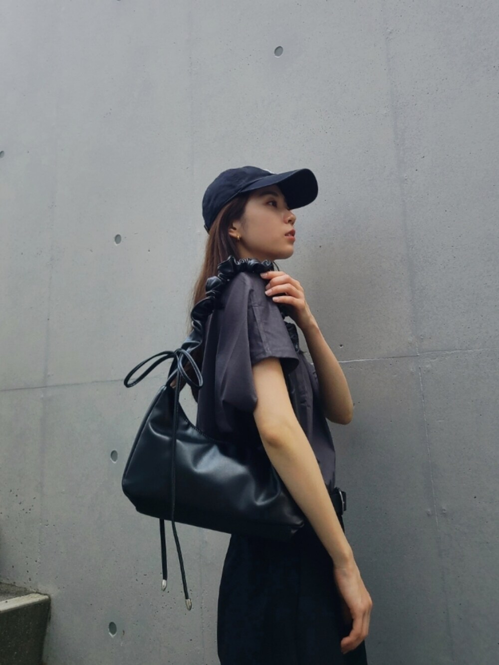 ブラック系のその他パンツ、ブラック系のショルダーバッグ、グレー系のトップスを着用したレディースの春コーディネートの2枚目の写真