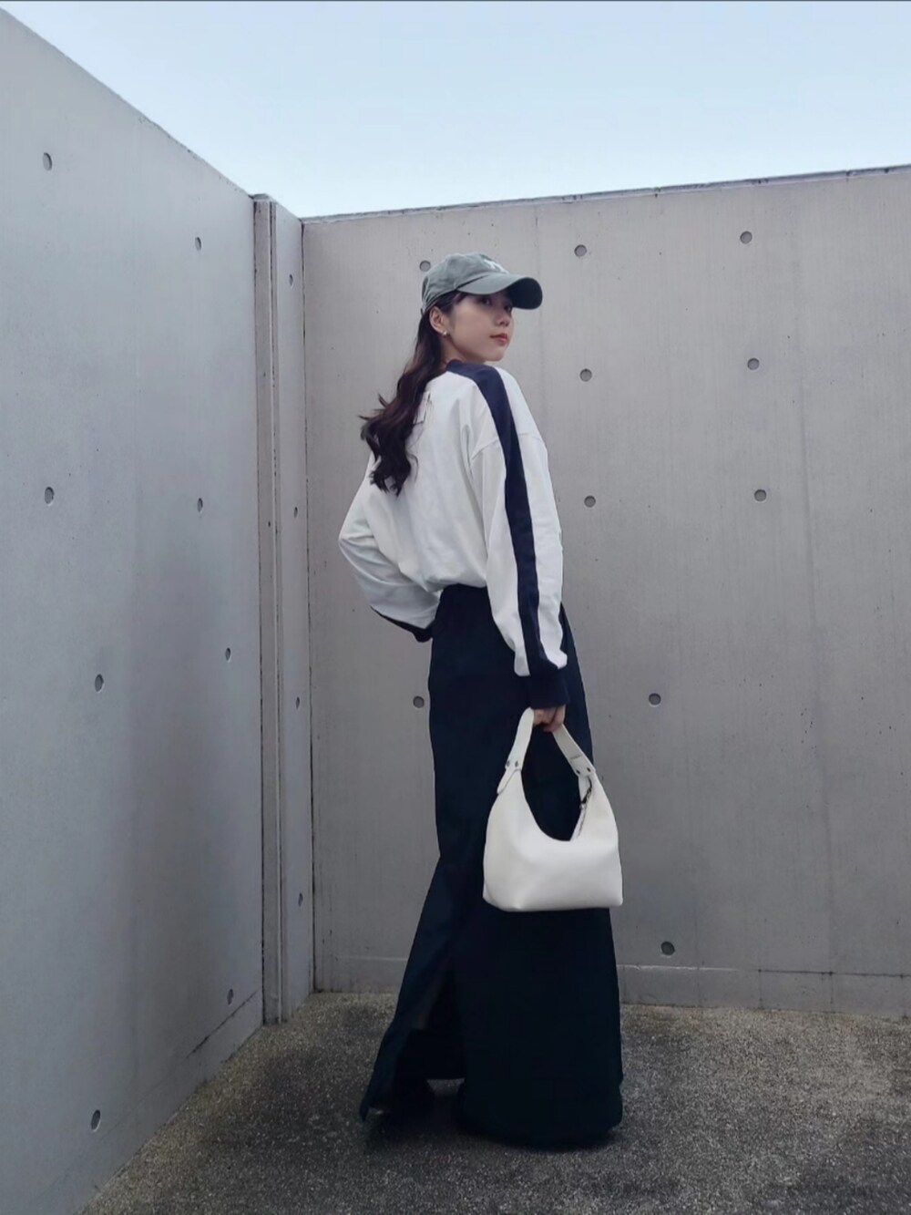 ホワイト系のハンドバッグ、ホワイト系のTシャツ/カットソー、グリーン系のキャップを着用したレディースの春コーディネートの4枚目の写真