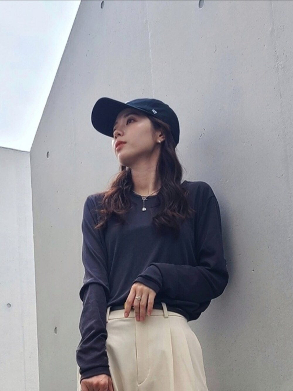 ホワイト系のバッグ、ホワイト系のパンツ、ブラック系のサンダルを着用したレディースの夏コーディネートの4枚目の写真